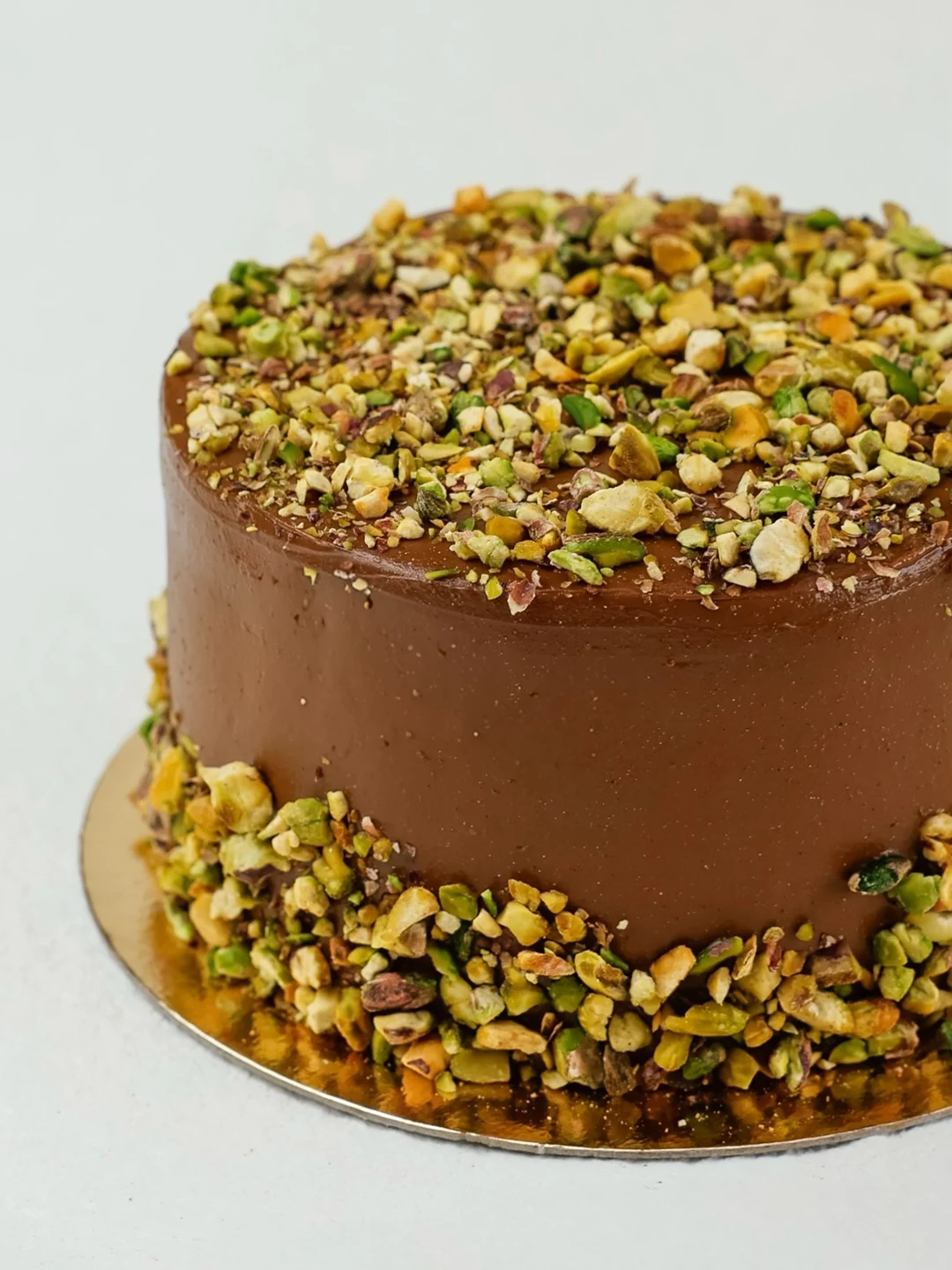 Bolo inteiro de pistache com cobertura de chocolate
