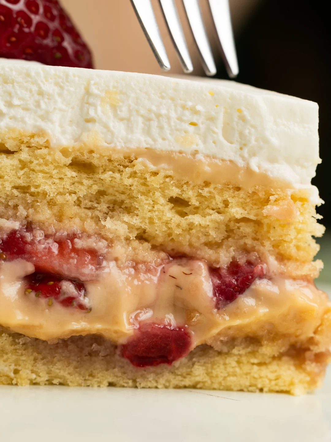 Fatia do bolo de morango com camadas de creme